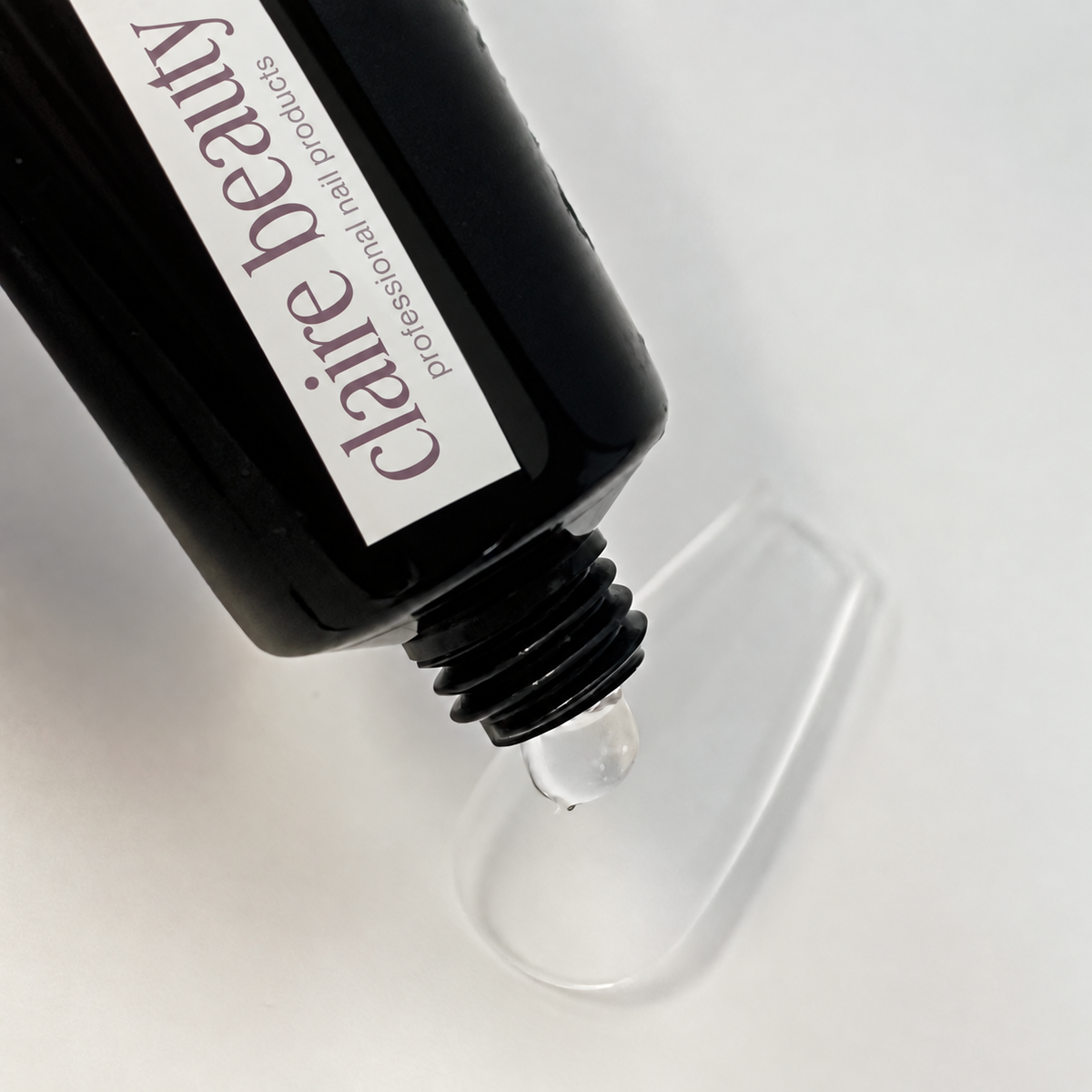 claire beauty Press On Glue Gel wird aus der Tube auf einen transparenten Nageltip dosiert