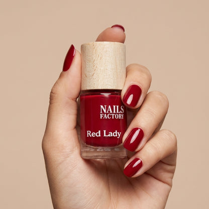 Grüner, pflanzenbasierter Nagellack Red Lady von claire beauty auf einem weißen Hintergrund.