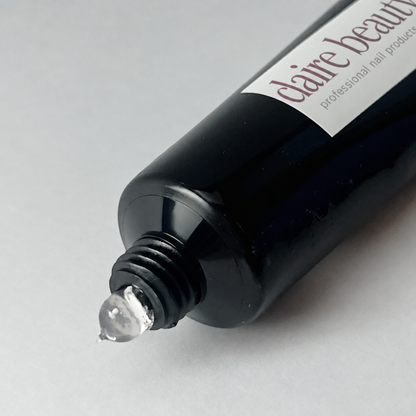 Transparente, standfeste Geltextur des claire beauty Press On Glue Gels an der geöffneten Tube