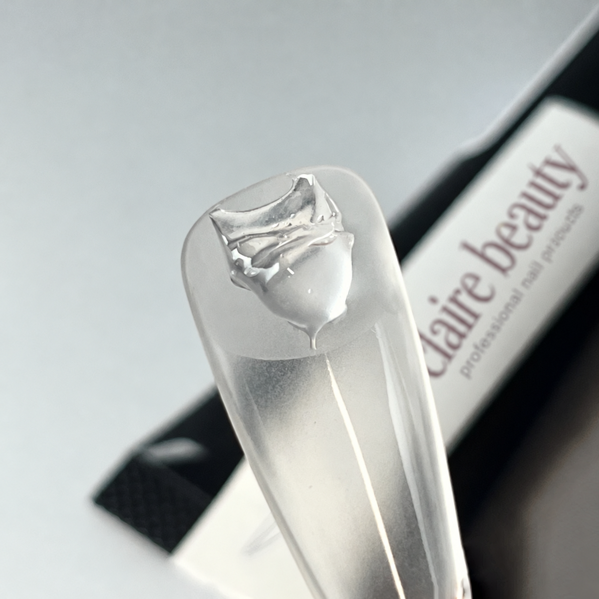 claire beauty Press On Glue Gel auf der Kontaktfläche eines transparenten Full-Cover-Tips